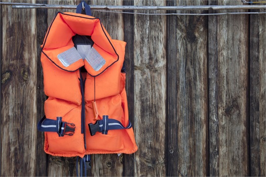 life jacket hanging on wood fence