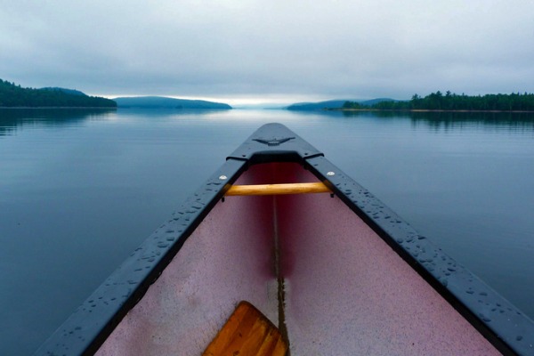 canoe on still lake at dusk